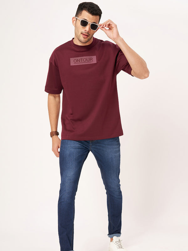 Maroon T-shirt with dark blue jeans